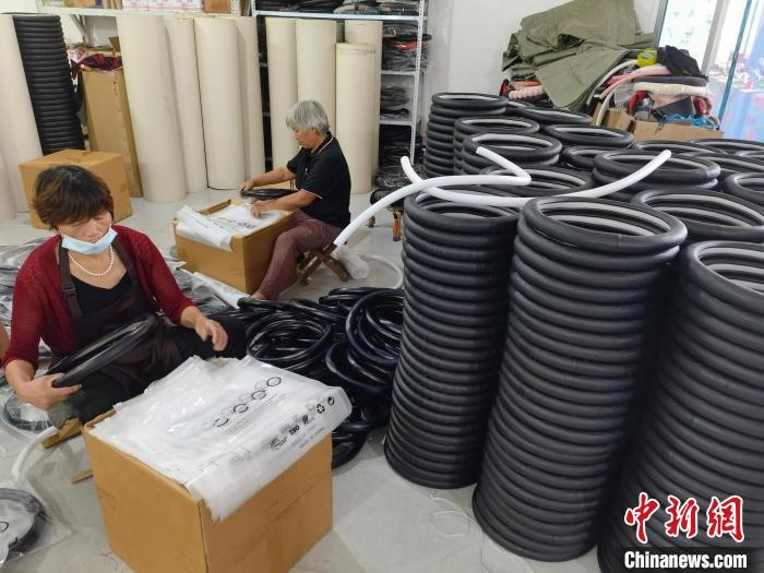 圖為村民在汽車飾品企業(yè)生產(chǎn)車間中工作?！巫雍?攝