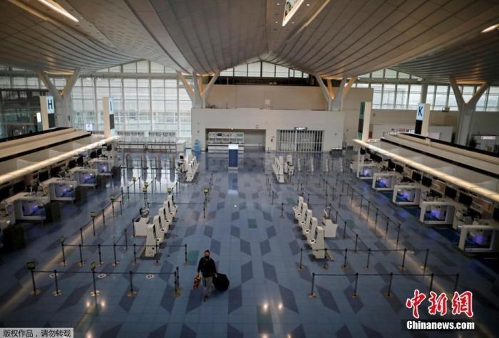 資料圖：日本東京，東京國際機場，一名乘客在國際航班航站樓的登機區(qū)。