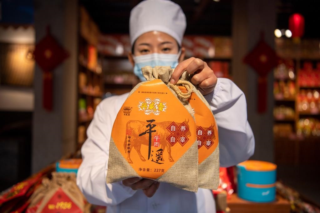 1月27日，在平遙古城南大街的一家平遙牛肉店內(nèi)，工作人員展示一款牛肉產(chǎn)品。新華社記者 楊晨光 攝
