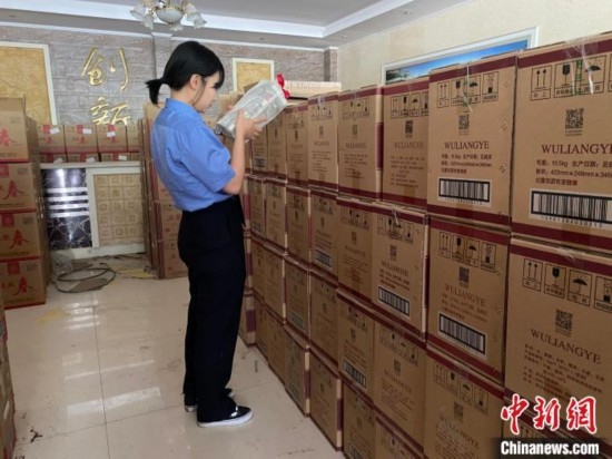資料圖為檢察人員核對查獲的假冒品牌白酒。青海省人民檢察院供圖