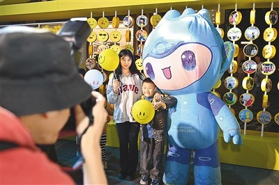 5月7日，在浙江省杭州市湖濱步行街“3D笑臉墻”前，攝影師為游客與杭州亞運會吉祥物之一“宸宸”拍攝合影。
