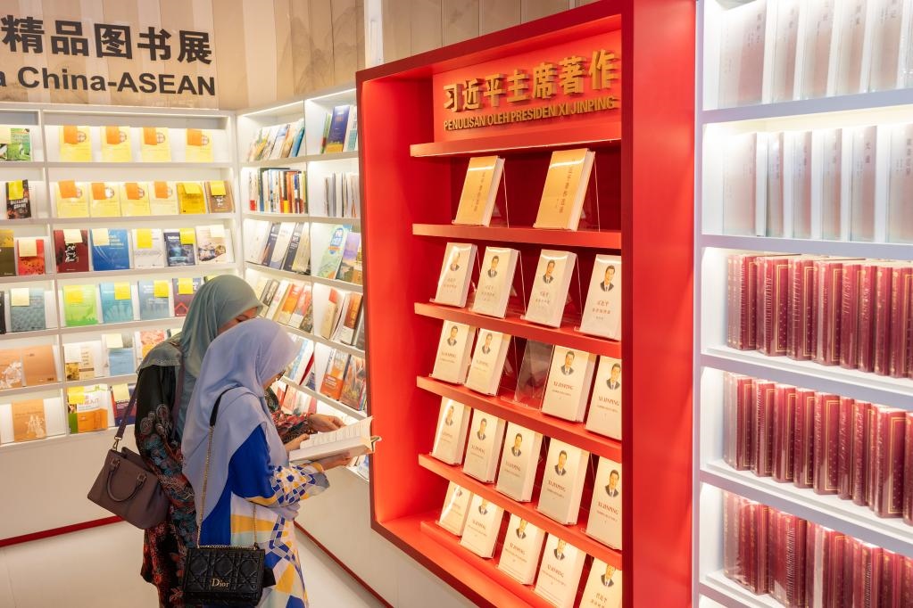5月30日，兩名讀者在馬來西亞吉隆坡國際書展中國主賓國活動現(xiàn)場閱讀習(xí)近平主席著作。新華社記者朱煒攝