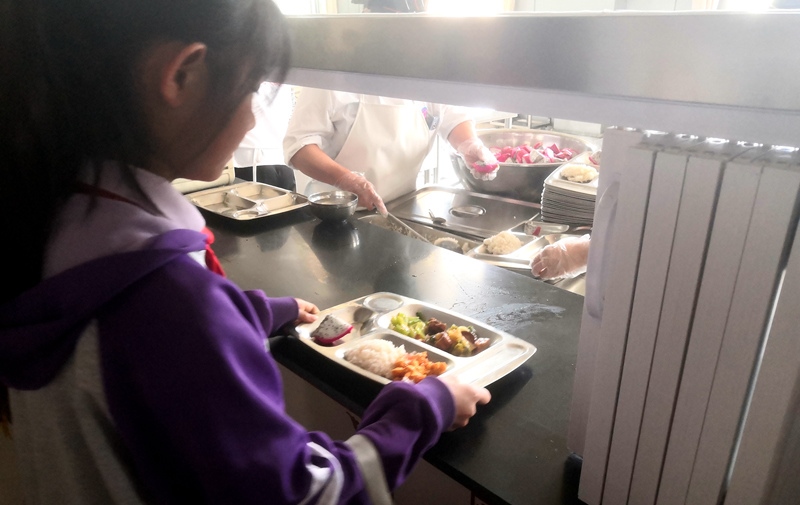伊金霍洛旗第一小學(xué)學(xué)生正在打飯，今天的飯菜是三菜一湯外加水果，學(xué)生可以多次盛取，吃飽為止。人民網(wǎng)記者 孫博洋攝