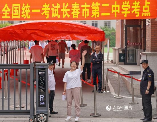 6月7日，在長春市第二中學(xué)考點，一名考生信心滿滿進入考場，并與家長揮手致意。人民網(wǎng)記者 李洋攝