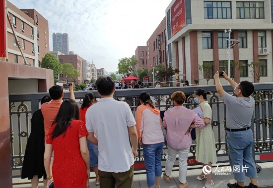 6月7日，武漢市第三中學(xué)考點，考生進場后，家長在柵欄外用手機拍攝自己的孩子。人民網(wǎng)記者 郭婷婷攝