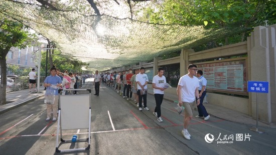 6月7日，烏魯木齊市第七十中學(xué)門口，考生們有序進入考場。人民網(wǎng) 李欣洋攝