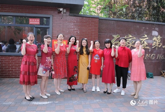 6月7日，在石家莊第二十七中學(xué)考點，家長身著旗袍，為高考的孩子們加油助威！紅紅火火、旗開得勝！人民網(wǎng)記者 周博攝