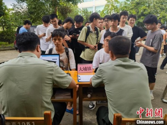 專武干部在發(fā)放兵役登記證。韋碩 攝
