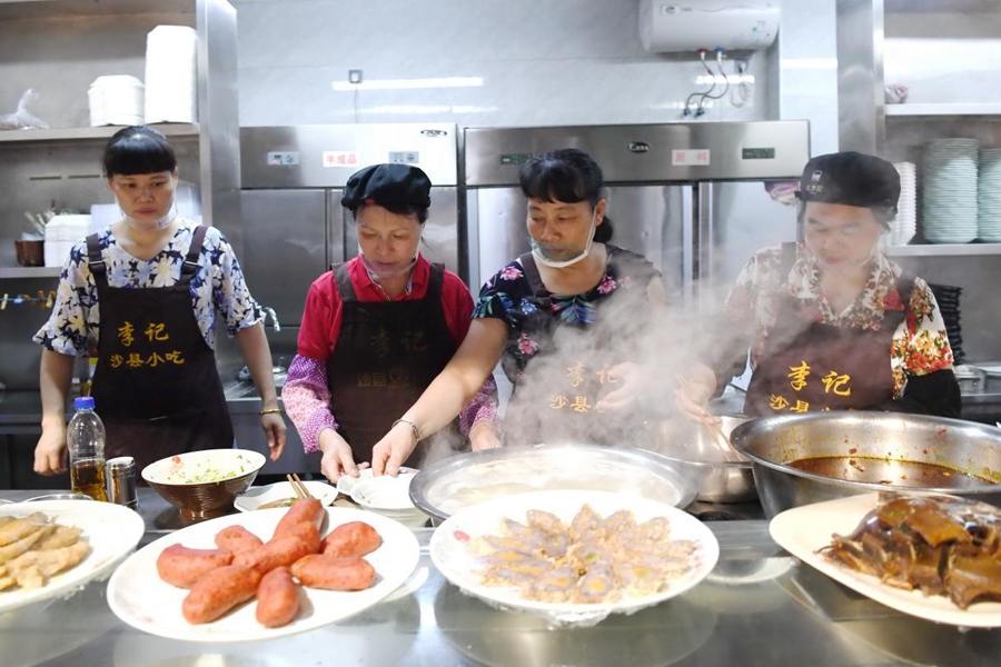 福建三明市沙縣區(qū)一家小吃店工作人員在為客人準(zhǔn)備特色小吃。 新華社記者 林善傳 攝