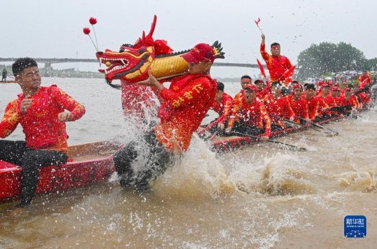 6月22日，在湖南省岳陽市湘陰縣湘江臨資口水域，參加龍舟賽的隊員接“龍頭”下水。