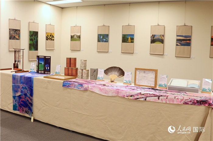 現(xiàn)場展出的馮學敏攝影作品與湖州市特色工藝品。（人民網(wǎng) 許可攝）