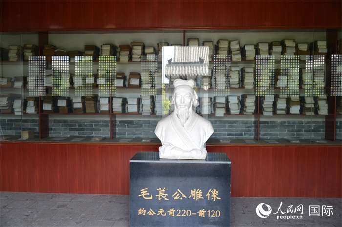 河間詩(shī)經(jīng)齋毛萇雕像。雕像后書(shū)櫥中陳列的是歷代各版本《詩(shī)經(jīng)》及譯本。 人民網(wǎng) 趙昭攝