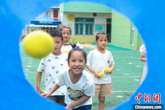 在肥西縣山南鎮(zhèn)中心幼兒園，孩子們在玩布洞投球游戲。陳家樂 攝