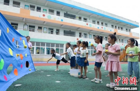 在肥西縣山南鎮(zhèn)中心幼兒園，孩子們在玩布洞投球游戲。陳家樂 攝