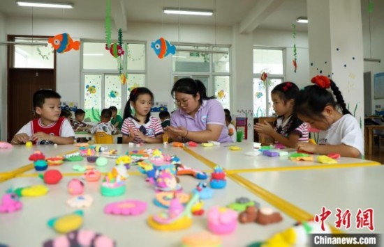 在肥西縣山南鎮(zhèn)中心幼兒園，孩子們在老師的指導(dǎo)下做彩色泥塑。陳家樂 攝