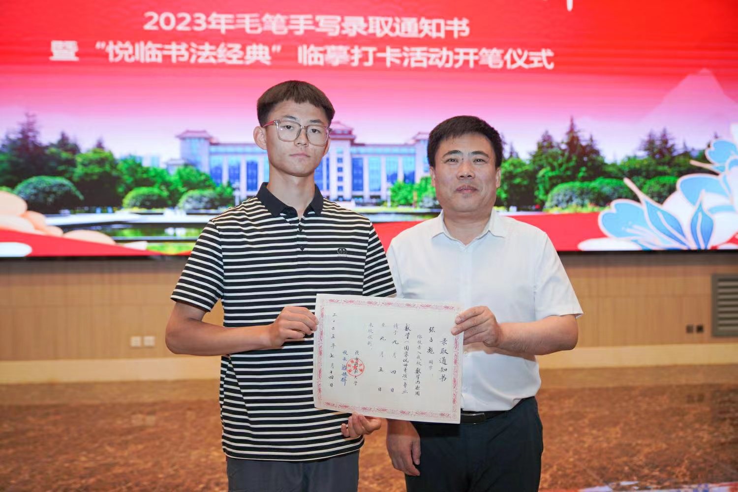 陜西師范大學(xué)黨委書記李忠軍為2023級新生代表張占彪同學(xué)發(fā)放錄取通知書。校方供圖
