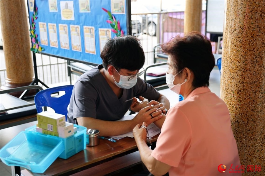 泰國中醫(yī)師為當?shù)孛癖娞峁┲嗅t(yī)咨詢、診療服務。人民網(wǎng)記者 楊一攝