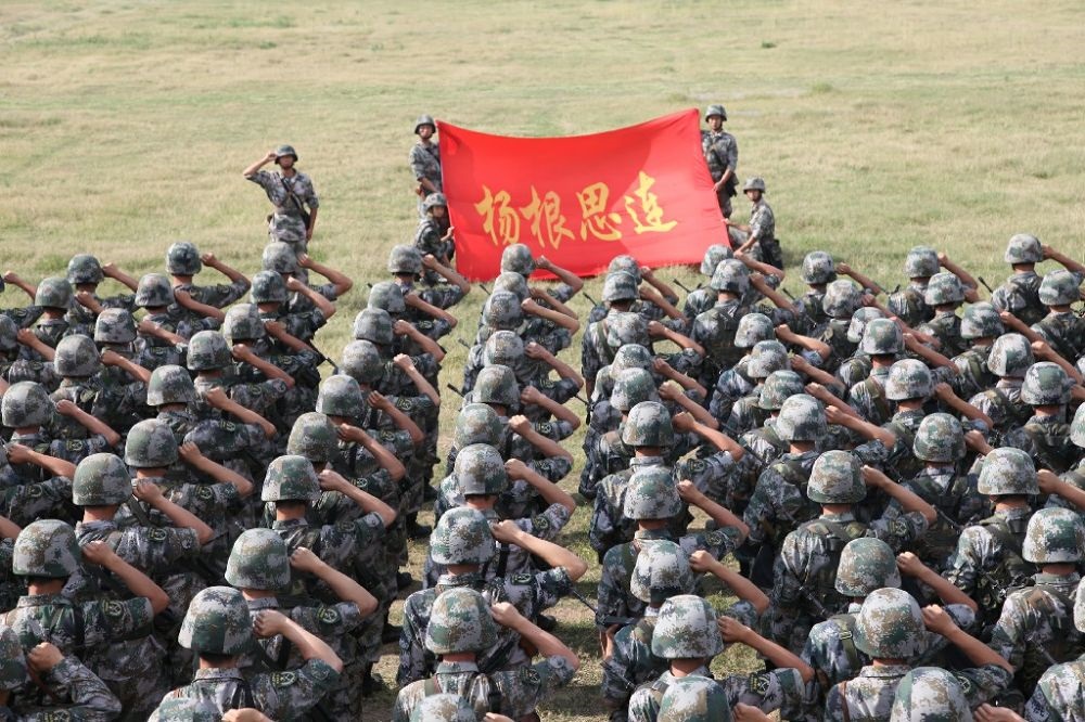 ↑“楊根思連”官兵執(zhí)行任務(wù)前向連旗宣誓（資料照片）。新華社發(fā)