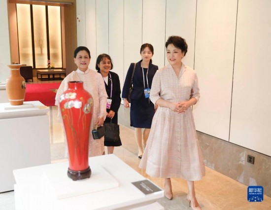 7月27日下午，國家主席習近平夫人彭麗媛在四川成都會見陪同印度尼西亞總統(tǒng)佐科來華出席第31屆世界大學生夏季運動會開幕式并訪華的總統(tǒng)夫人伊莉亞娜。這是彭麗媛和伊莉亞娜欣賞成都特色非遺工藝品。新華社記者 丁林 攝