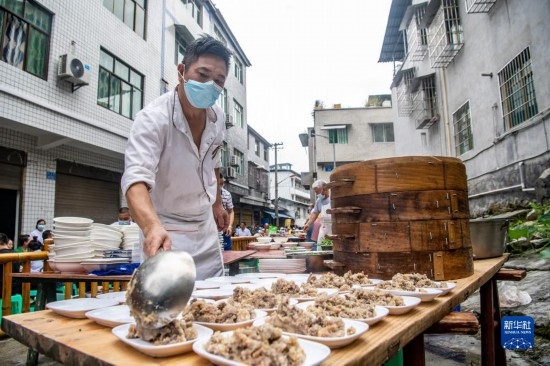 7月29日，在重慶市綦江區(qū)安穩(wěn)鎮(zhèn)，當?shù)鼐用裨凇懊缂曳蚬?jié)”上準備羊肉長桌宴。新華社記者 唐奕 攝