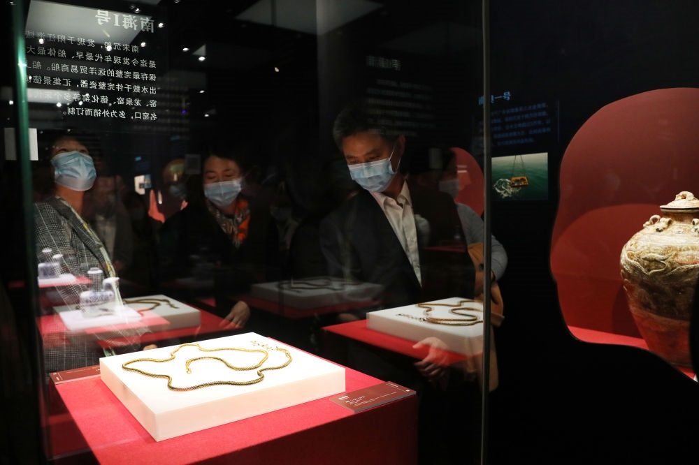 參觀者在上海臨港新城的中國航海博物館航海文物展上的“南海一號”出水的宋代金項飾展柜前駐足觀看（2020年12月28日攝）。新華社記者 方喆 攝