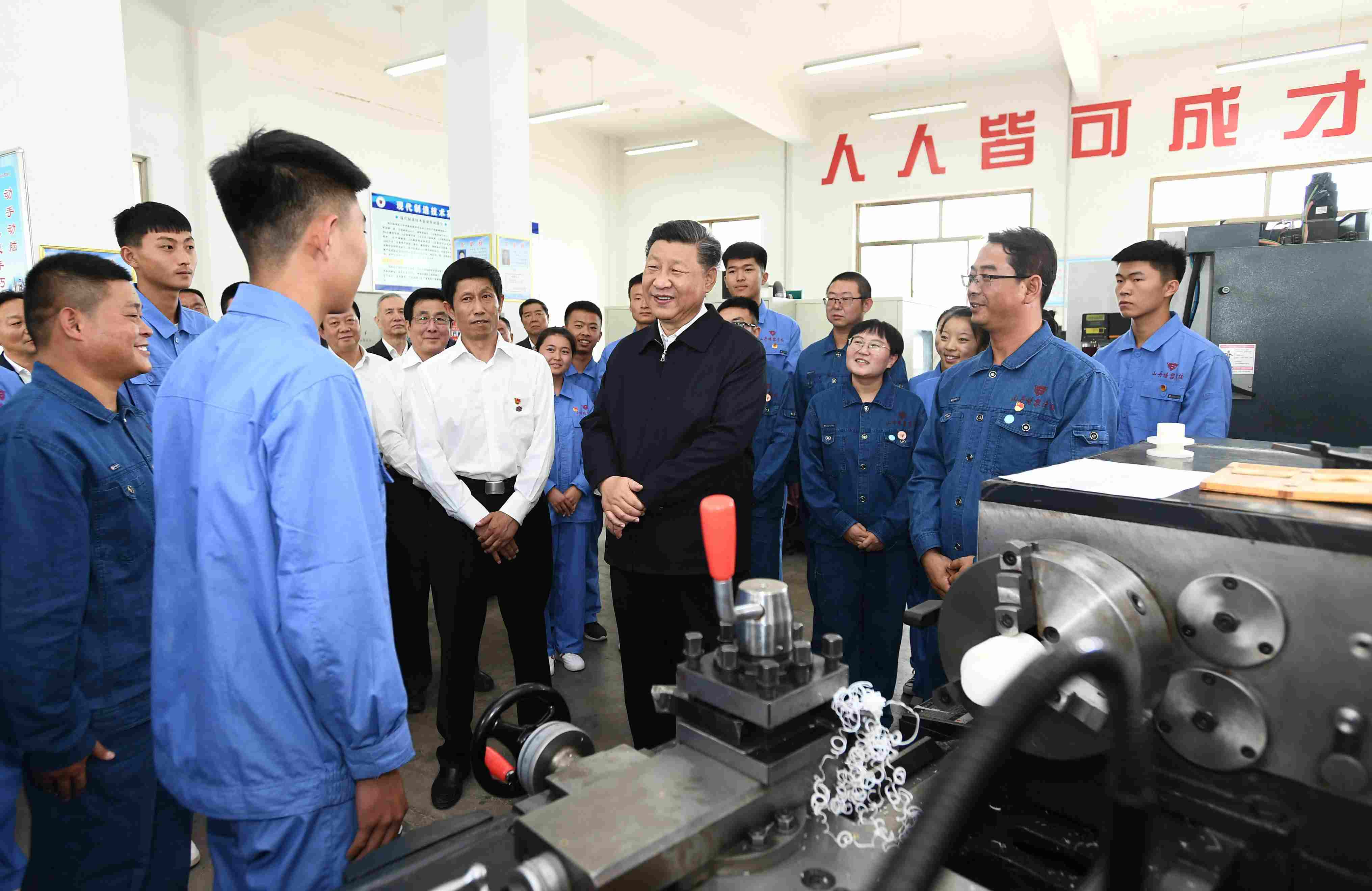 2019年8月20日，習(xí)近平在甘肅省張掖市山丹培黎學(xué)校現(xiàn)代制造技術(shù)實(shí)訓(xùn)室，觀看職業(yè)技能實(shí)訓(xùn)，同師生親切交流。