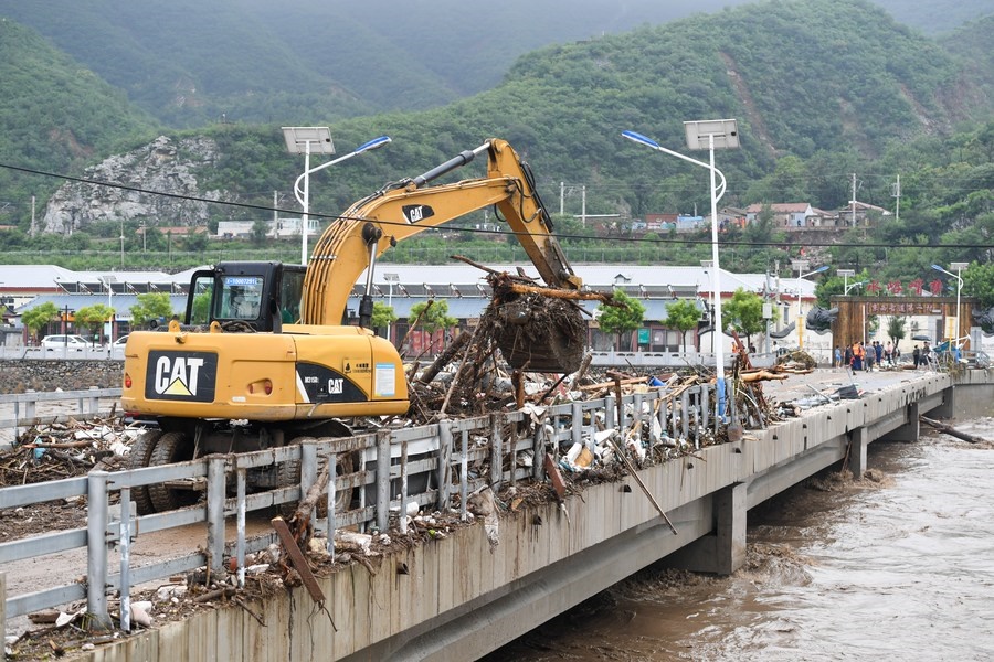 8月1日，在北京市門頭溝區(qū)水峪嘴村村口，一臺挖掘機(jī)在清理阻斷橋梁交通的雜物。目前該條道路已經(jīng)疏通完成。新華社記者 鞠煥宗 攝