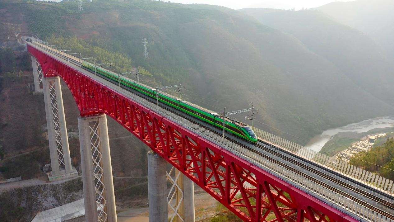 中老鐵路國(guó)際旅客列車在云南省境內(nèi)的元江特大橋上飛馳。姚巍攝