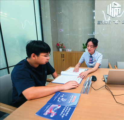 在杭州市臨安區(qū)政務(wù)服務(wù)中心的“為企服務(wù)中心”，黨員志愿者（右）解答企業(yè)主的疑問（2023年7月7日攝）。徐昱攝/本刊