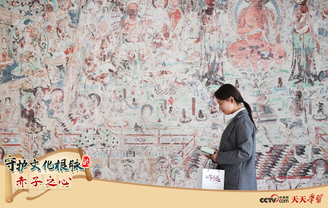 2023年4月25日，敦煌研究院文物數(shù)字化保護(hù)團(tuán)隊(duì)創(chuàng)意營(yíng)銷人員廖雪婷從一幅高保真復(fù)制壁畫前走過。