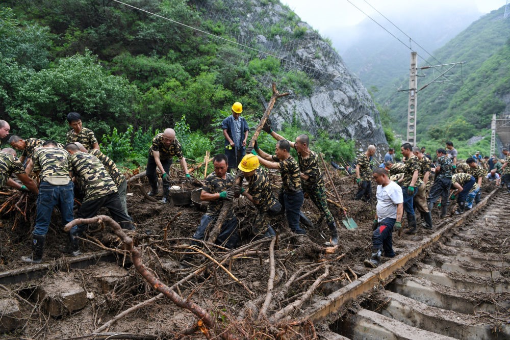 8月1日，在北京市門(mén)頭溝區(qū)水峪嘴村附近一段被阻斷的鐵路線上，中鐵六局工作人員在清理軌道上的雜物，全力恢復(fù)交通。新華社記者 鞠煥宗 攝