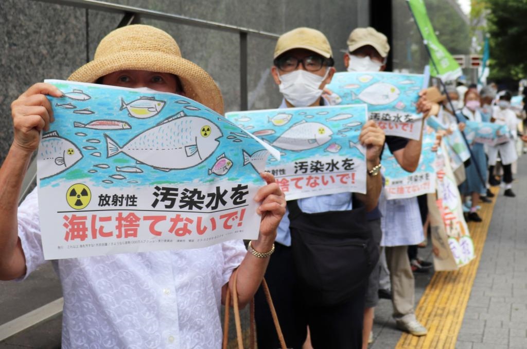 8月24日，日本民眾手持“不要將污染水扔進大?！钡葮?biāo)語在東京電力公司總部前集會，抗議日本政府和東電公司無視民意啟動核污染水排海。新華社記者楊光攝