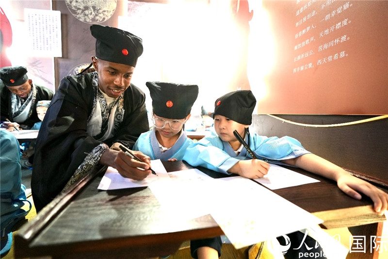 圖為選手與同學(xué)們一起寫書法。人民網(wǎng) 盧鵬宇攝