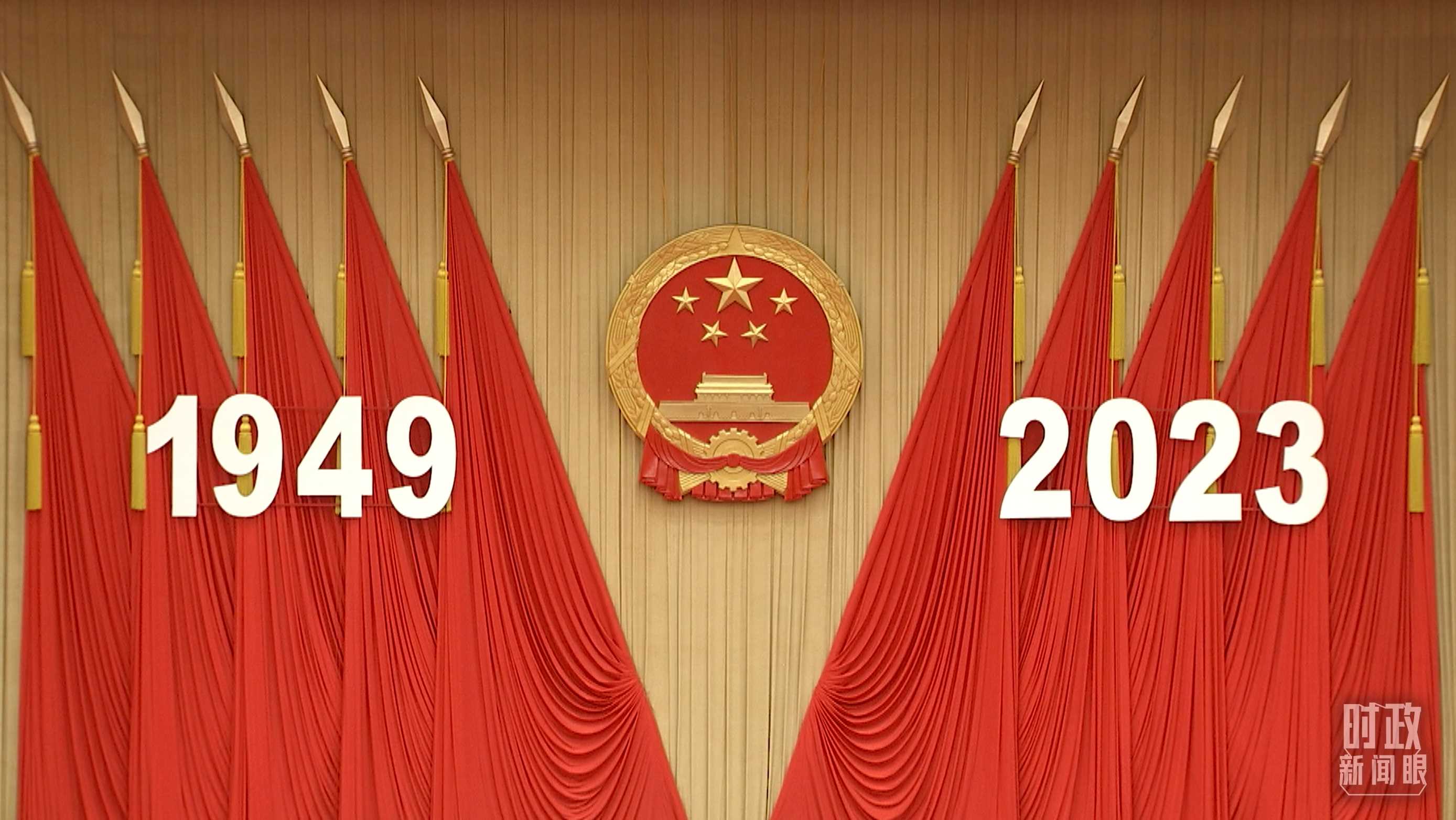 △人民大會堂宴會廳內(nèi)，主席臺上方高懸著莊嚴(yán)的國徽，“1949－2023”大字年號在鮮艷的紅旗映襯下格外醒目。