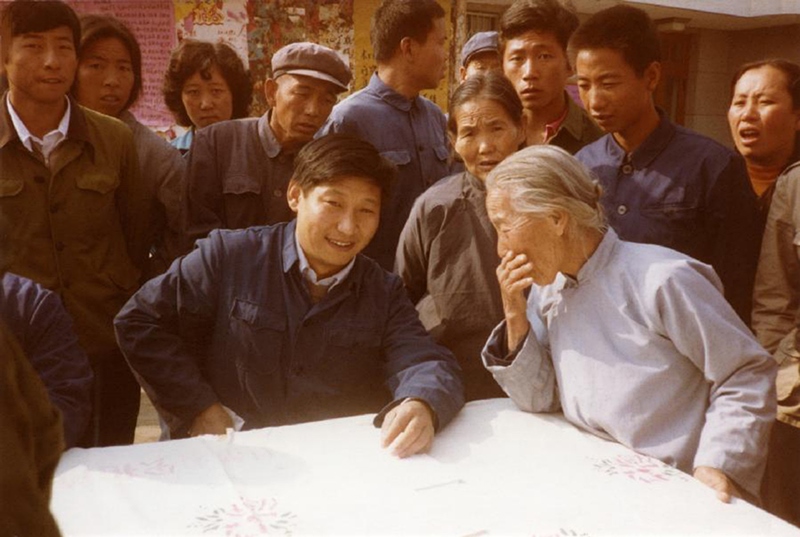 1983年，時(shí)任河北正定縣委書記的習(xí)近平（前排居中）臨時(shí)在大街上擺桌子聽(tīng)取老百姓意見(jiàn)。
