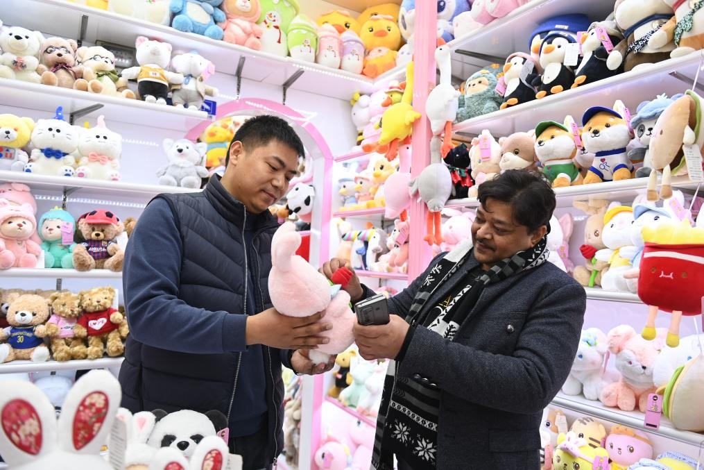 2023年2月2日，來自印度的客商（右）在義烏國際商貿(mào)城的一家玩具店鋪內(nèi)選購商品。新華社記者 黃宗治 攝