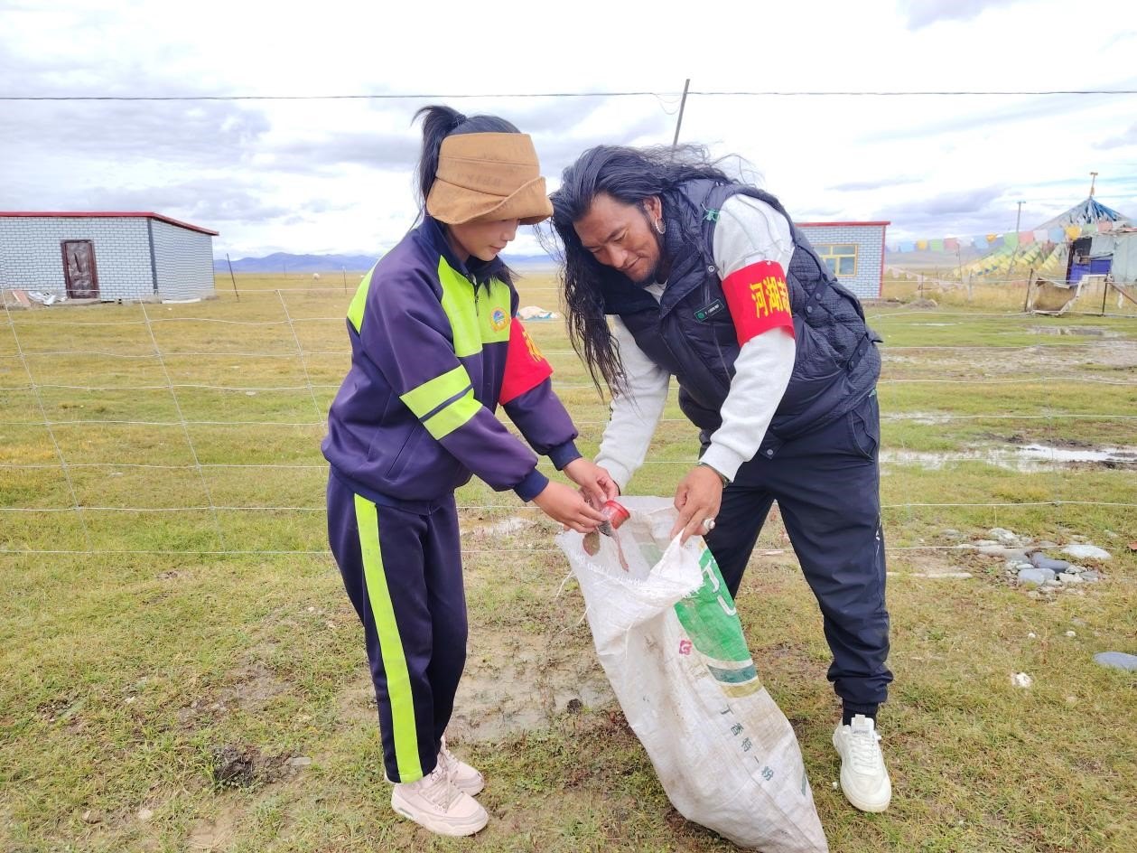 玉樹(shù)州稱(chēng)多縣珍秦鎮(zhèn)河湖志愿者才培和他女兒更求拉毛在清掃垃圾。受訪(fǎng)者供圖