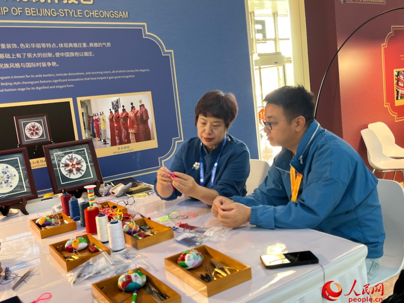 記者在新聞中心非遺傳承人展區(qū)進(jìn)行體驗(yàn)。人民網(wǎng)記者 杜燕飛攝