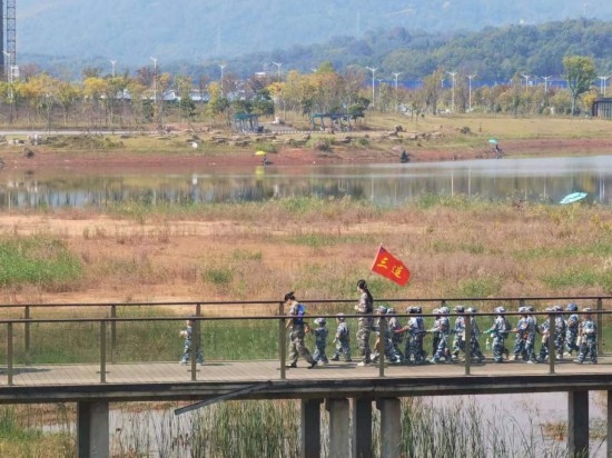 10月24日，秋游的幼兒園小朋友在老師帶領(lǐng)下走在清水塘公園里的木橋上。本報記者 常雯宜攝