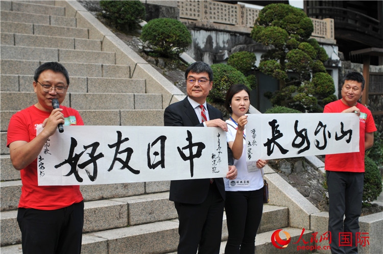 東京中國(guó)文化中心主任羅玉泉展示其為本次活動(dòng)書寫的題詞“中日友好，山高水長(zhǎng)”。人民網(wǎng) 蔣曉辰攝