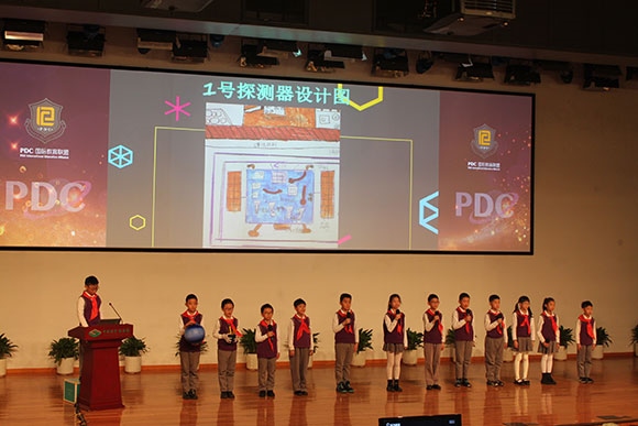 北京呼家樓中心小學的學生們展示PDC項目“新行星移民計劃探索衛(wèi)星設計”。