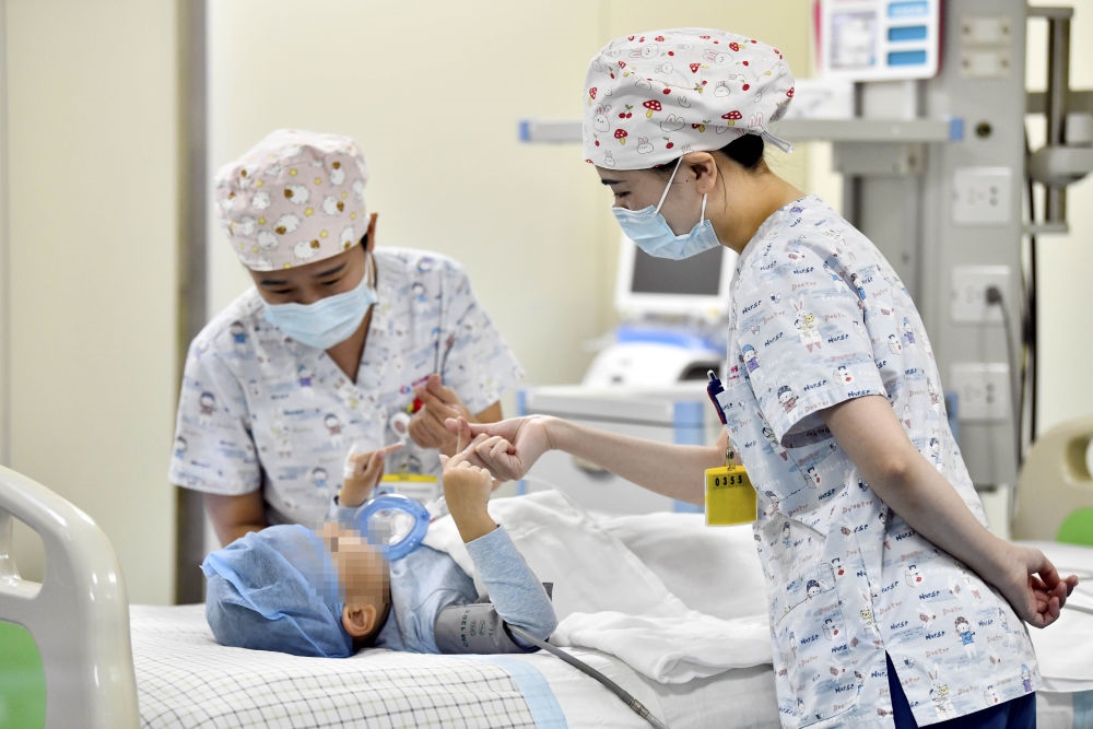 在山東省棗莊市婦幼保健院兒童ICU病房，醫(yī)護(hù)人員為完成靶向治療藥物諾西那生鈉的4歲脊髓性肌萎縮癥患兒加油鼓勁（2022年1月1日攝）。諾西那生鈉注射液是我國首個獲批治療脊髓性肌萎縮癥的進(jìn)口藥物，2019年進(jìn)入中國市場時，每針價格近70萬元。在2021年國家醫(yī)保目錄藥品談判中，以3.3萬元每針的價格進(jìn)入新版醫(yī)保藥品目錄。新華社記者 郭緒雷 攝