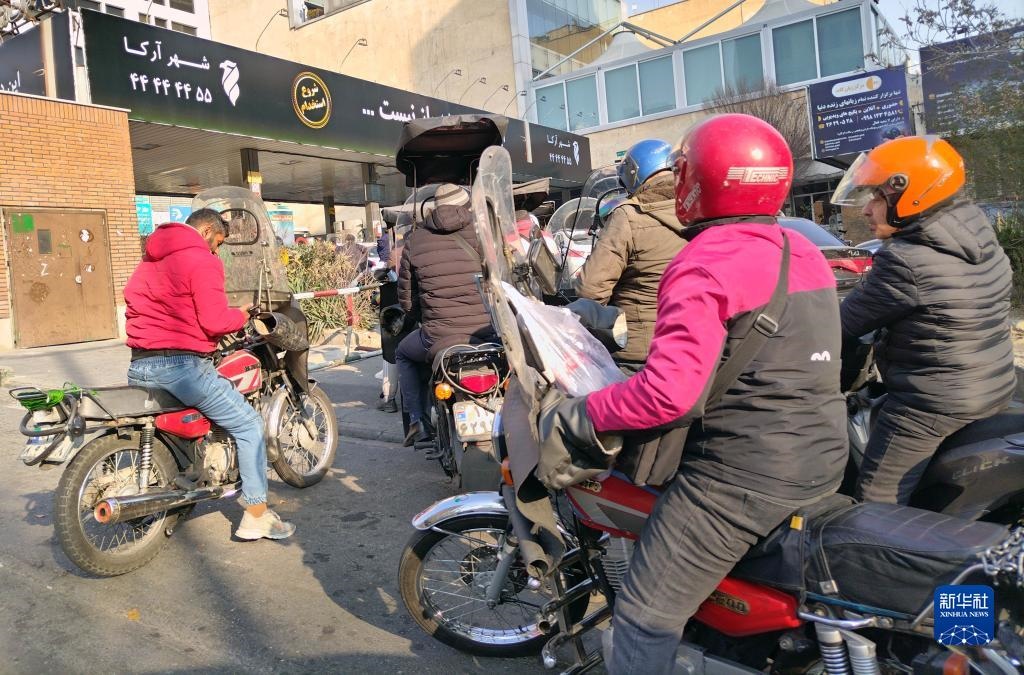 12月18日，摩托車在伊朗首都德黑蘭的一家加油站外等待加油。新華社記者 沙達提 攝