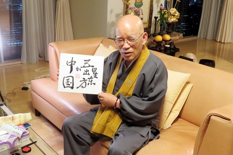 小島康譽(yù)展示自己書(shū)寫(xiě)的“五星出東方利中國(guó)”。視頻截圖