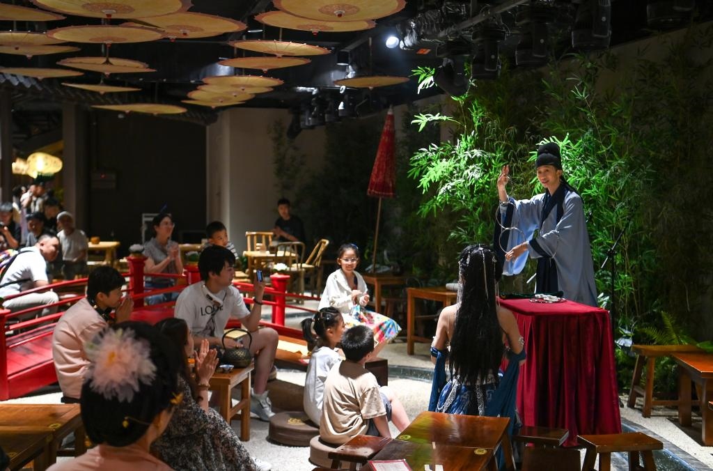 游客在長安十二時辰主題街區(qū)觀看唐風演藝《大唐曲藝》。新華社記者鄒競一 攝