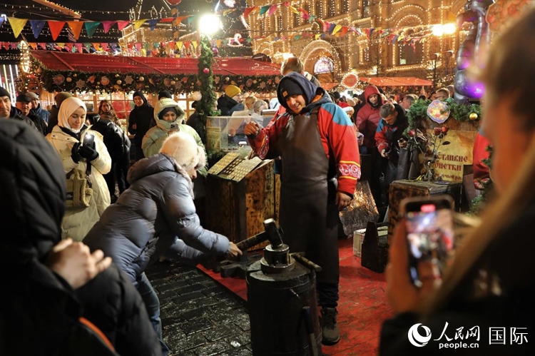 游客在新年集市上體驗(yàn)制作紀(jì)念幣。人民網(wǎng)記者 隋鑫攝
