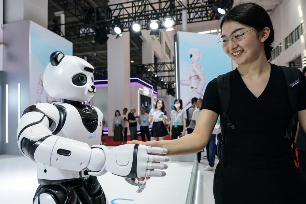 2023年8月16日，一名女士在北京舉辦的2023世界機(jī)器人大會(huì)現(xiàn)場(chǎng)與智能機(jī)器人握手。新華社記者彭子洋攝