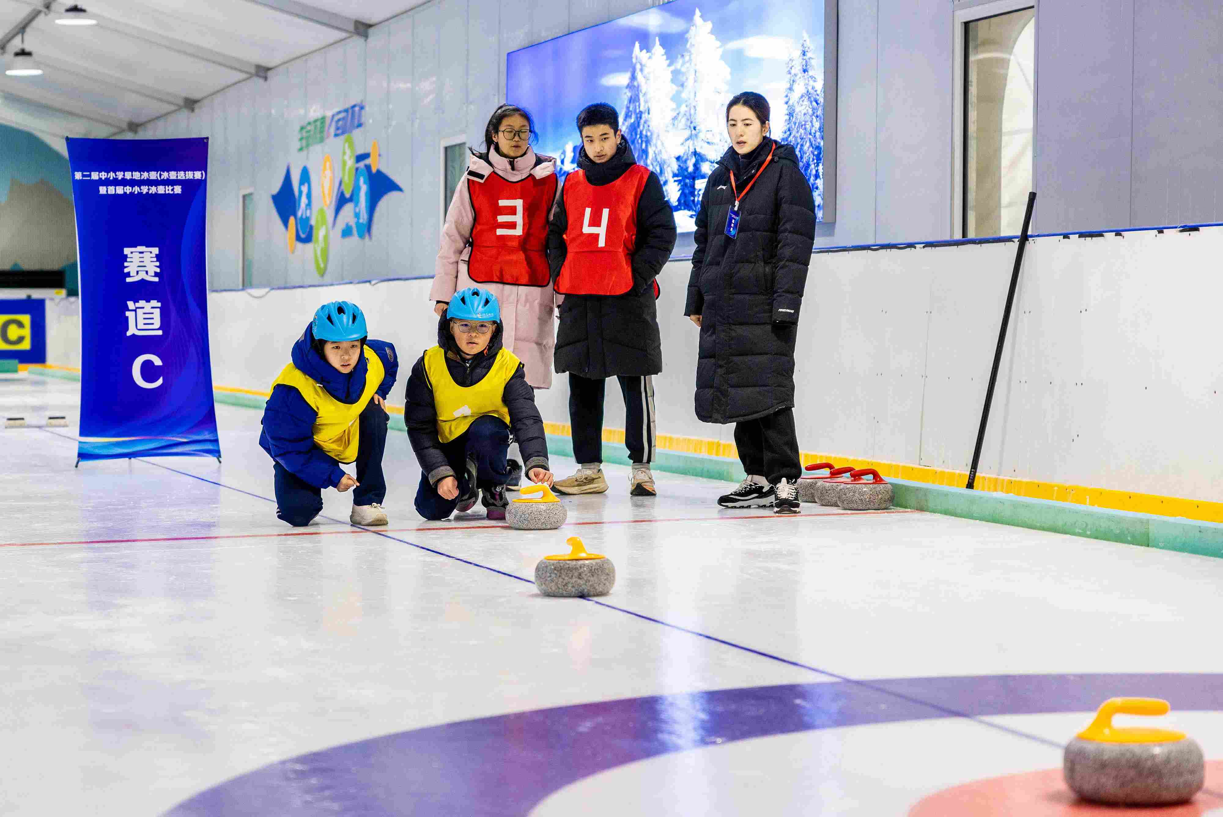2023年12月10日，參賽選手在呼和浩特首屆中小學(xué)冰壺比賽中投擲冰壺。