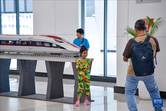 1月24日，在印度尼西亞雅加達(dá)哈利姆站候車大廳，一名小朋友和雅萬高鐵高速動(dòng)車組模型合影。新華社記者 徐欽 攝