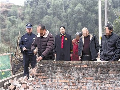  圖③：庭審結束后，在法官的見證下，陳某在院壩邊重新開鑿一條通道。